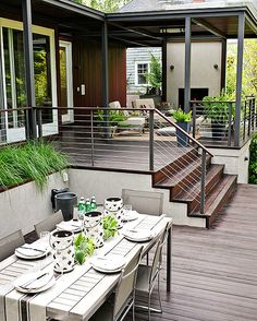 an outdoor dining area with wooden decking and white table set for four on the patio