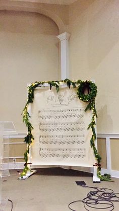 a large sheet of paper with greenery on it sitting in front of a wall