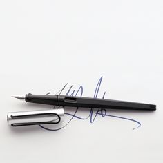 a pen and signature on a white surface