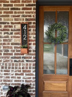 a front door with a wreath on it and a sign that says 477 next to the door