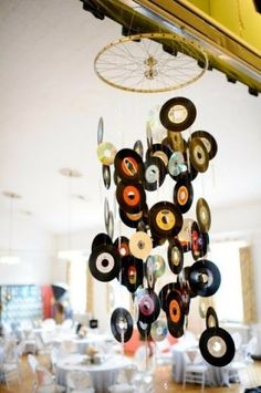 a wind chime hanging from the ceiling in a room filled with tables and chairs