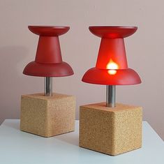 two red lamps sitting on top of blocks with a light in the middle between them