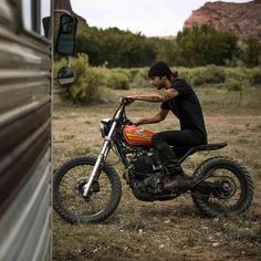 a man riding on the back of a dirt bike next to a motorhome