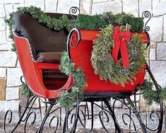 a red sleigh with wreaths and decorations on it