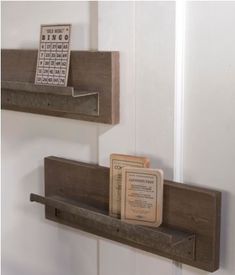 two wooden shelves holding books and calendars on the wall next to eachother