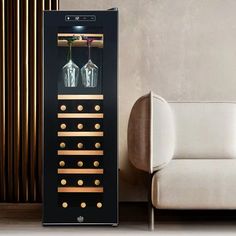 a black wine cooler sitting next to a white couch in a room with gold trim