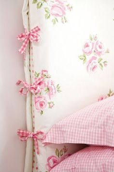 a bed with pink flowers and gingham sheets