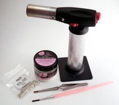 a hairdryer, scissors, and other items are sitting on a white surface