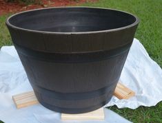 a large black pot sitting on top of a white cloth next to a wooden stick