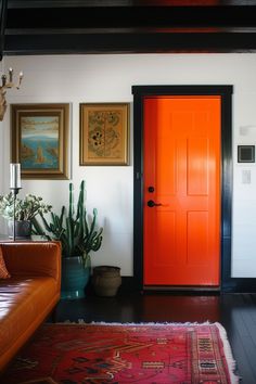 a living room with an orange door and rug