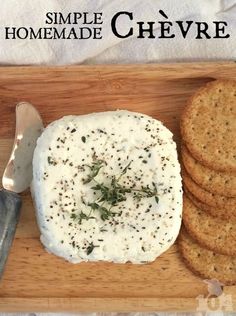 a wooden cutting board topped with cheese and crackers