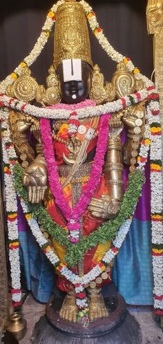 the statue is decorated with flowers and garlands