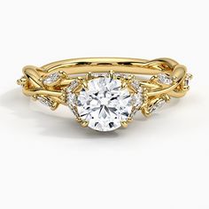 a yellow gold engagement ring with an oval cut diamond surrounded by two smaller round diamonds