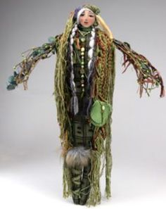 the doll is dressed in green and has feathers on it's head, arms and legs