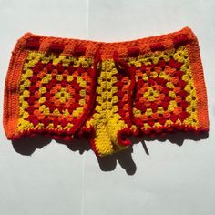 an orange and yellow crocheted dishcloth on a white surface