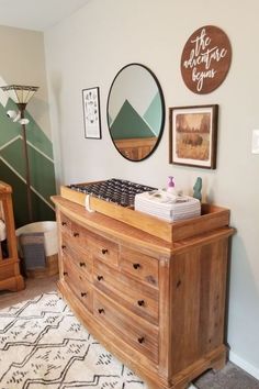 a baby crib in the corner of a room with pictures on the wall above it