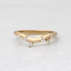 a gold ring with three small diamonds on the top and one smaller diamond in the middle