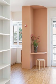 a vase with flowers sitting on top of a table in a room next to a window