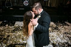 a bride and groom kissing in front of confetti strewn on the dance floor