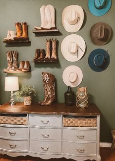 hats and boots are displayed on the wall above a dresser