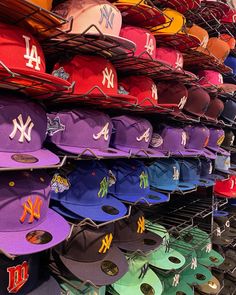 many hats are on display in a baseball hat store, all different colors and sizes