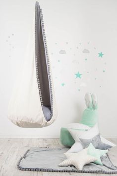 a child's room with stars and clouds on the wall, including a hammock