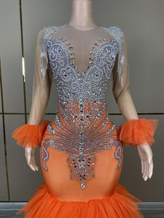 a mannequin dressed in an orange and silver dress