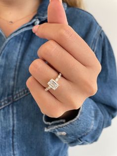 a woman's hand wearing a diamond ring