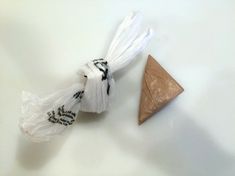 a piece of wood is next to a plastic bag with some white string on it