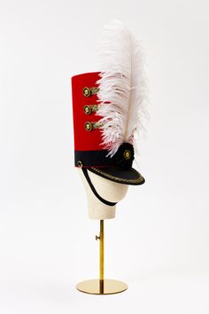 ...large and in charge Look dutiful and beautiful when you arrive to the Met in this elegant Nutcracker Hat and a black velvet column gown. The luxurious ostrich feather plume flutters and flounces as perfect foil to the otherwise structured look of this hat, handmade exclusively for Houses & Parties by milliner M Nutcracker Hat Template, Elaborate Christmas Hats, Nutcracker Hat Diy, Diy Nutcracker Hat, Nutcracker Hat, Nutcracker Dress, Majorette Costumes, Carol Songs, Nutcracker Costumes