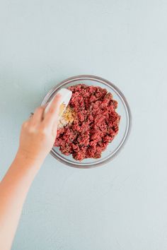 someone is mixing food in a glass bowl