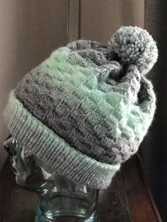 a knitted hat sitting on top of a glass vase