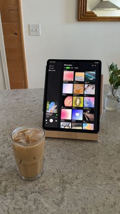 a tablet sitting on top of a table next to a cup of coffee and a mirror