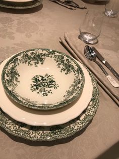 two green and white plates sitting on top of a table next to utensils