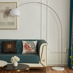 a living room with a couch, table and lamp on the wall next to it