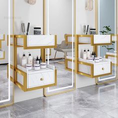 a white and gold bathroom with mirrors on the wall next to it's sinks