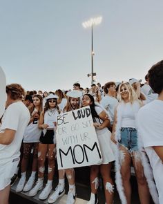 a group of people standing next to each other holding a sign that says be loud or go sit with us mom