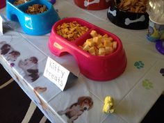 there is a dog bowl with food in it on the table next to other bowls