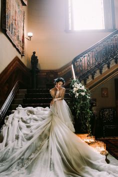 a woman in a wedding dress standing on some stairs