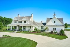 a large white house sitting on top of a lush green field