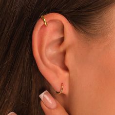 a close up of a person's ear with two piercings on the side