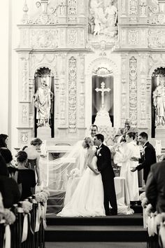 a bride and groom standing in front of the alter