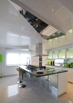 a modern kitchen with stainless steel appliances and counter tops, along with white walls and flooring