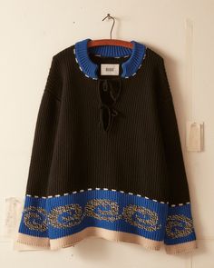 a black and blue sweater hanging on a wall