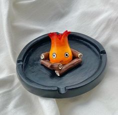 an orange and black object with eyes on it's face sitting in a bowl