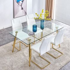 a glass dining table with white chairs and a blue vase filled with flowers on top