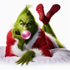 a man dressed as the grinch is laying on a bed with his tongue out