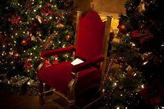 a red chair sitting in front of a christmas tree