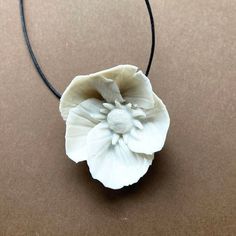 The Striped Anemone necklace is handmade . Every flower is handmade one by one in white porcelain clay, dryed and  fired in the very high temperature to ensure the clay is robust, assembled with a black cotton  thread. Please handle with attention due to the fine nature of porcelain.The flower is  3.5 / 4 cm diameter.The lenght is about 17.8 inch / 45 cm. I can customize lenght as you want. White Clay Jewelry As A Gift, White Necklaces With Handmade Flowers As Gift, Unique White Jewelry With Flower Charm, White Necklaces With Handmade Flowers For Gift, Delicate White Handmade Flower Necklace, White Adjustable Nature-inspired Necklace, Handmade Clay Flower Jewelry, Delicate Handmade White Flower Necklace, Adjustable White Nature-inspired Necklace