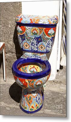 a colorful toilet sitting on top of a stone floor next to a wall and door